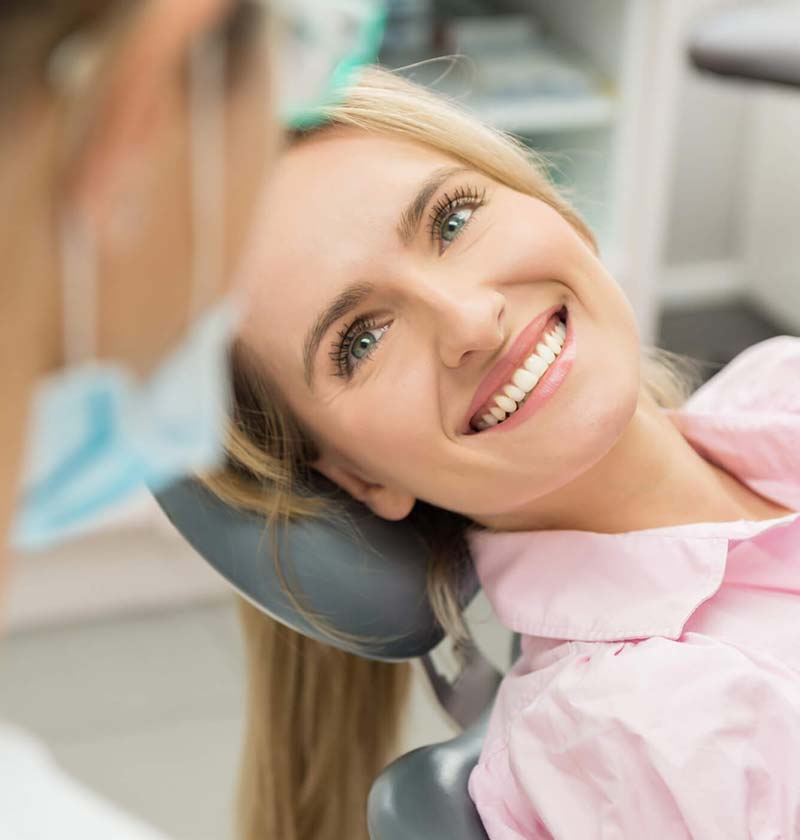 Woman sitting on dental chair smiling