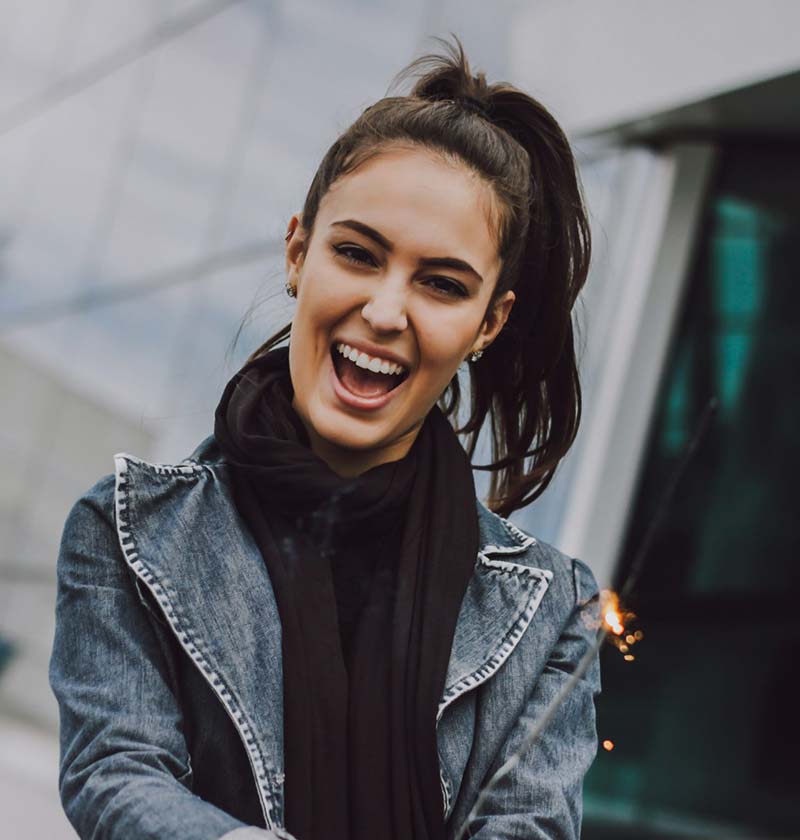 Brunette wearing a jean jacket smiling