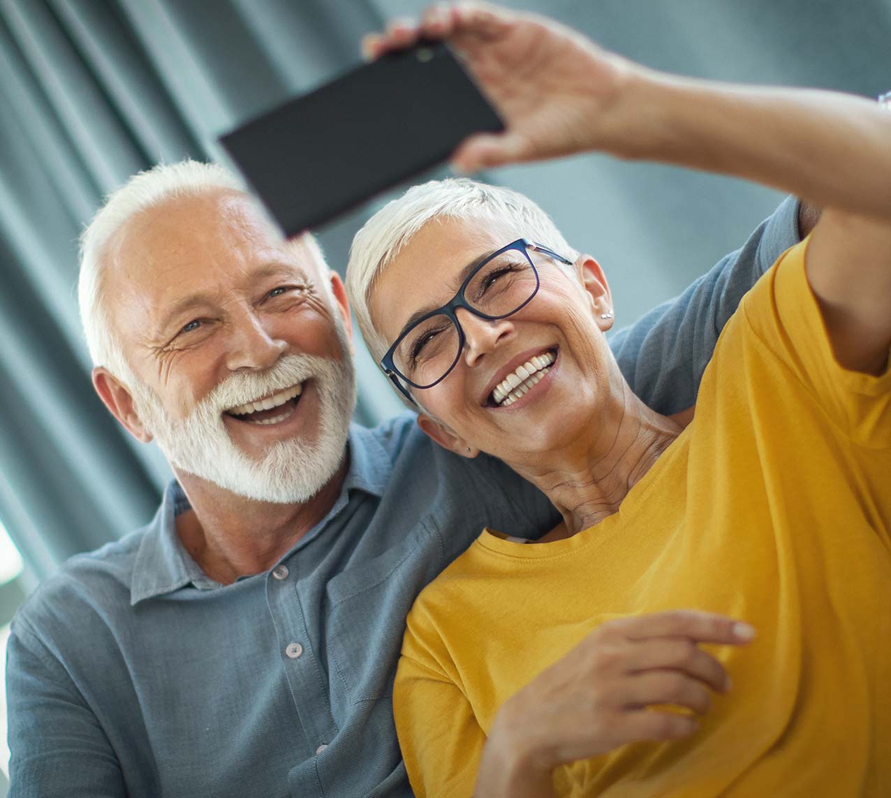 Couple in their 60's smiling and taking a selfie