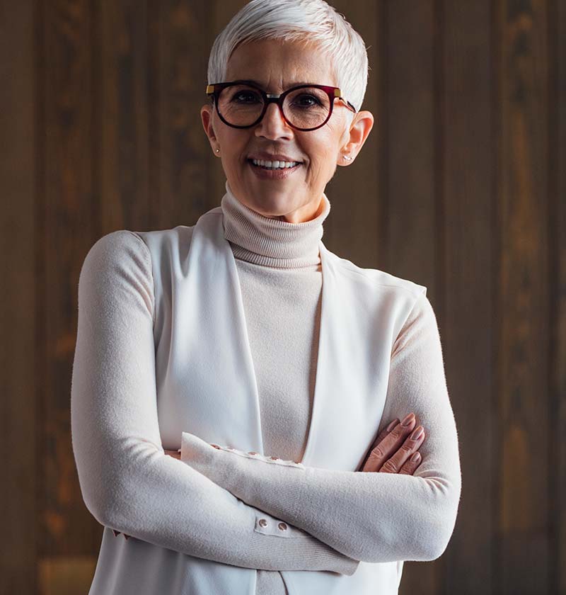 Woman in her 60's wearing glasses smiling