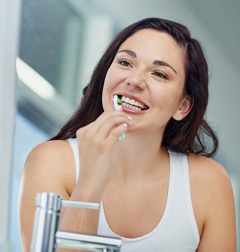 Young female brushing her teeth